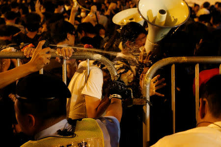 Demonstrators are pepper sprayed by police during a protest against what they call Beijing's interference over local politics and the rule of law, a day before China's parliament is expected to announce their interpretation of the Basic Law in light of two pro-independence lawmakers' oath-taking controversy, in Hong Kong, China, November 6, 2016. REUTERS/Tyrone Siu TPX IMAGES OF THE DAY