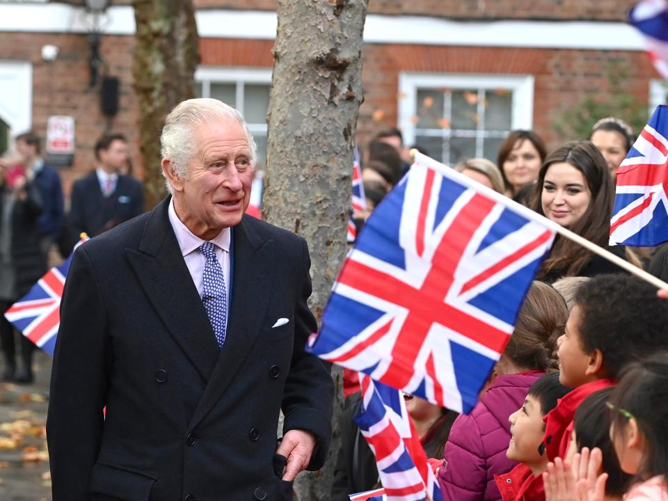 King Charles III meets pupils waving Union Jack flags from the new City junior school, based within the grounds, during a visit to The Honourable Society of Gray’s Inn on November 23, 2022 in London, England.