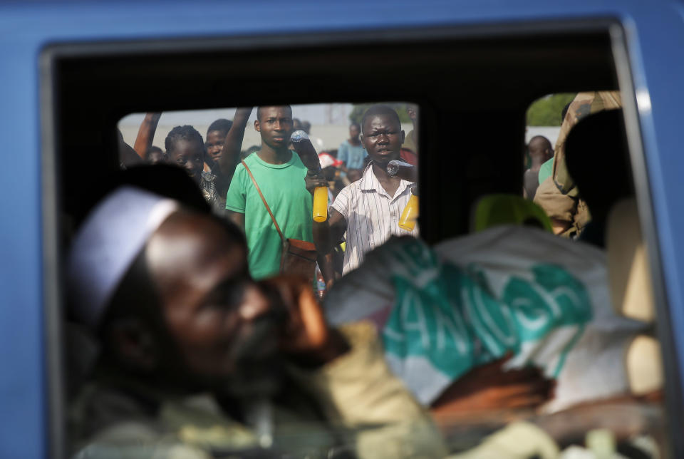 Christian bystanders watch thousands of Muslim residents from Bangui and Mbaiki flee the Central African Republic capital Bangui in a mass exodus using cars, pickups, trucks, lorries and motorcycles, escorted by Chadian troops Friday Feb. 7, 2014. Tit-for-tat violence killed more than 1,000 people in Bangui alone in a matter of days in December. An untold number have died in the weeks that followed, with most of the attacks in Bangui targeting Muslims. (AP Photo/Jerome Delay)