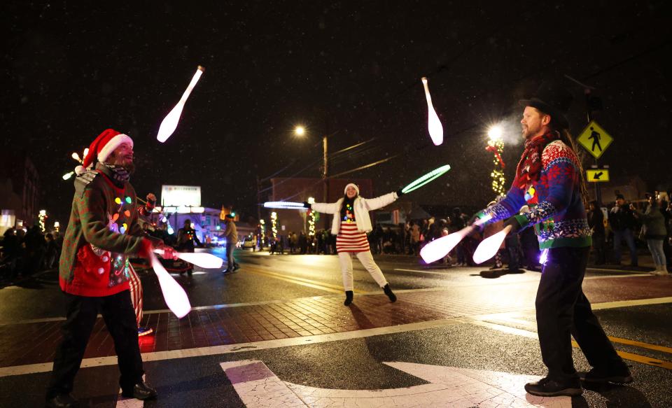 From left, Eric Girardi and Murray Eighne perform with juggling clubs at the Stoughton Holiday Parade of Lights on Saturday, Dec. 10, 2022.