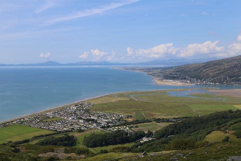 <span class="caption">A view of Fairbourne from above, showing the Mawddach estuary and the mountains of Eryri in the background. </span> <span class="attribution"><a class="link " href="https://www.shutterstock.com/image-photo/view-high-vantage-point-over-fairbourne-1475179817" rel="nofollow noopener" target="_blank" data-ylk="slk:Wozzie/Shutterstock;elm:context_link;itc:0;sec:content-canvas">Wozzie/Shutterstock</a></span>