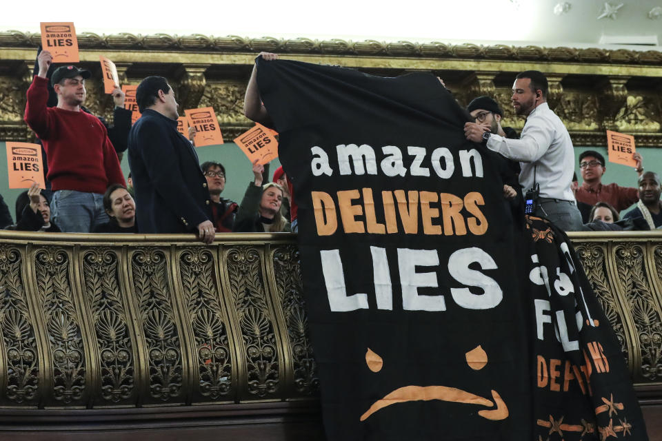 NEW YORK, NY - JANUARY 30: Protestors unfurl anti-Amazon banners from the balcony of a hearing room during a New York City Council Finance Committee hearing titled 'Amazon HQ2  Stage 2: Does the Amazon Deal Deliver for New York City Residents?' at New York City Hall, January 30, 2019 in New York City. Some Queens community members and activists say Amazon's move to Queens will further gentrify neighborhoods in the area and add more stress to an already struggling infrastructure system. (Photo by Drew Angerer/Getty Images)