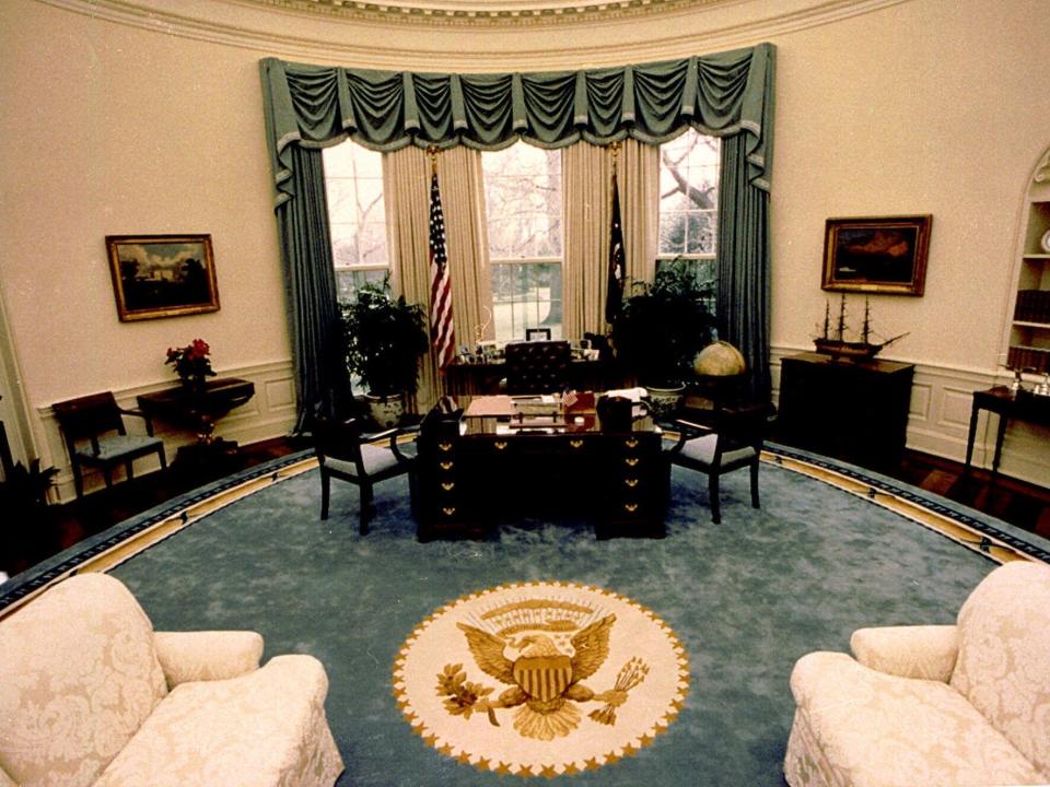 The Oval Office in 1990. It has a blue rug and blue curtains