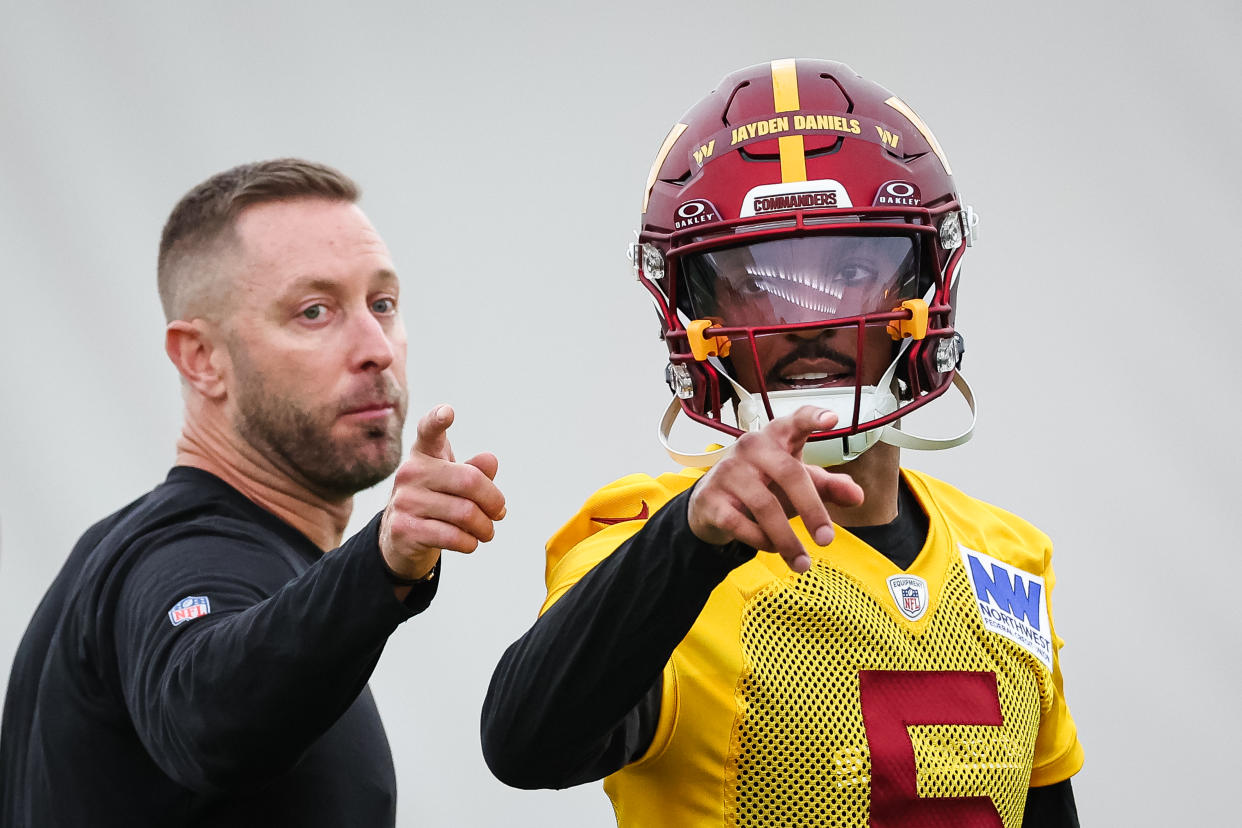 ASHBURN, VA - MAY 10: Offensive coordinator Kliff Kingsbury of the Washington Commanders instructs Jayden Daniels #5 during Washington Commanders Rookie Minicamp at OrthoVirginia Training Center on May 10, 2024 in Ashburn, Virginia. (Photo by Scott Taetsch/Getty Images)