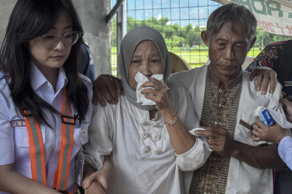 A relative of a victim of a train collision weeps in Cicalengka, West Java, Indonesia, Friday, Jan. 5, 2024. Two trains collided on Indonesia's main island of Java on Friday, causing several carriages to buckle and overturn, officials said. (AP Photo/Abdan Syakura)