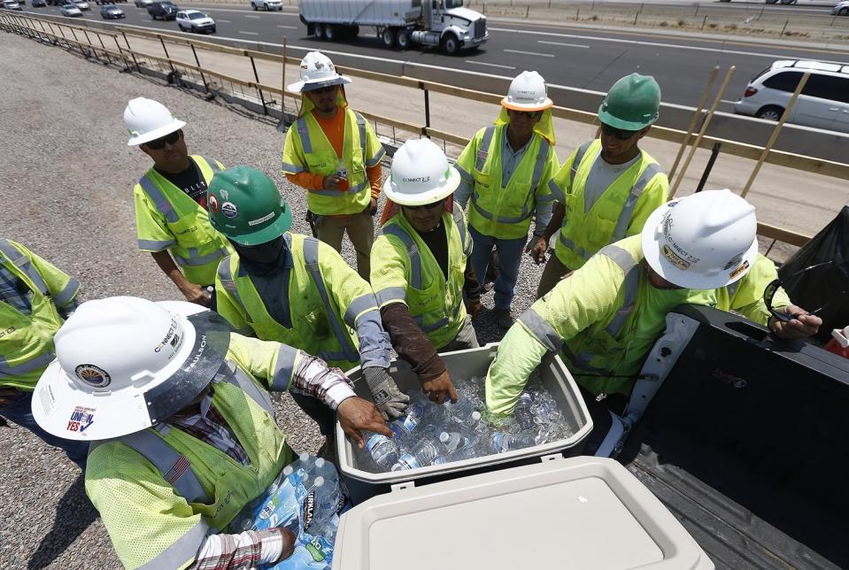 <p>Crew members building the Loop 202 South Mountain Freeway take a break as they try to keep hydrated and stay cool as temperatures climb to near-record highs, June 20, 2017, in Phoenix. (Ross D. Franklin/AP) </p>