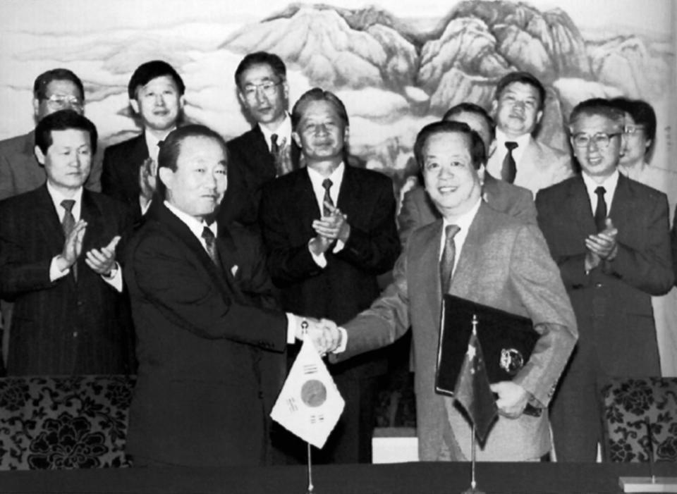 FILE - In this Aug. 24, 1992, file photo, South Korean Foreign Minister Lee Sang-Ock, left, and his Chinese counterpart Qian Qichen shake hands after signing an agreement establishing diplomatic relations between the two countries. North Korea turned to China, which saw preventing a North Korean collapse as crucial to its security interests. But their relations became complicated in 1992 when China established diplomatic relations with rival South Korea. (AP Photo/Greg Baker, File)