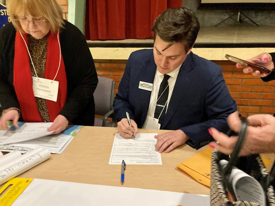 Miles Lucero, the Democratic candidate selected to run for county commissioner in District 1, signs paperwork after the Pueblo County Democratic Assembly on March 16, 2024.