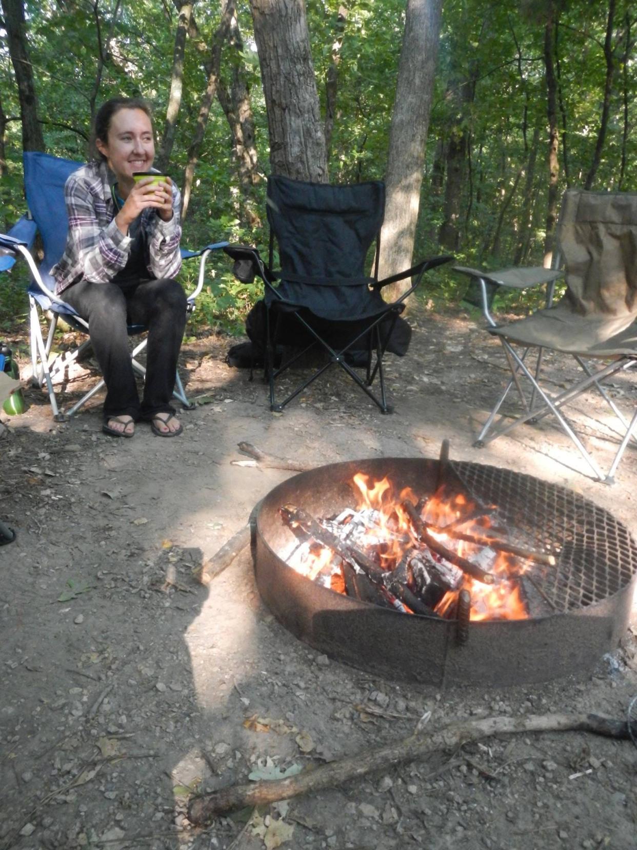 Milwaukee Journal Sentinel reporter Chelsey Lewis sits around a campfire at Governor Dodge State Park in Dodgeville.