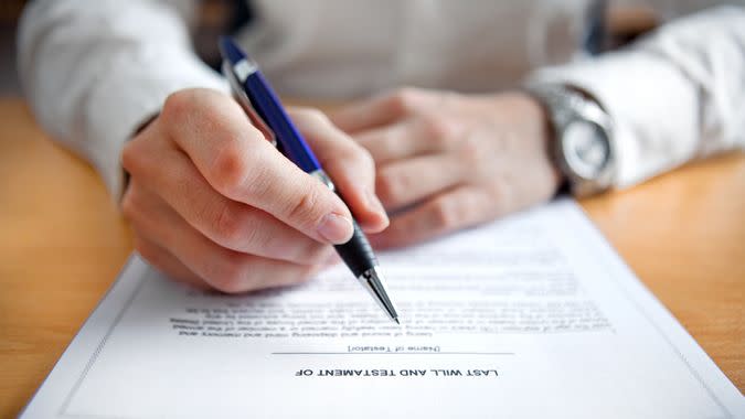 Female hands signing Last Will and Testament.