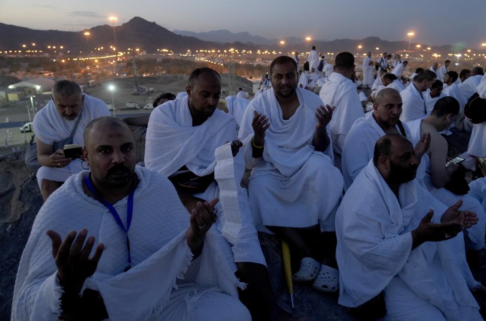 Muslim pilgrims pray on top of the rocky hill known as the Mountain of Mercy, on the Plain of Arafat, during the annual hajj pilgrimage, near the holy city of Mecca, Saudi Arabia, Friday, July 8, 2022. (AP Photo/Amr Nabil)