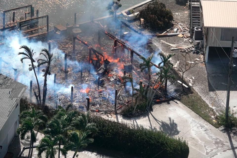 A building in Fort Myers smoulders after it caught fire during Hurricane Ian (AP)