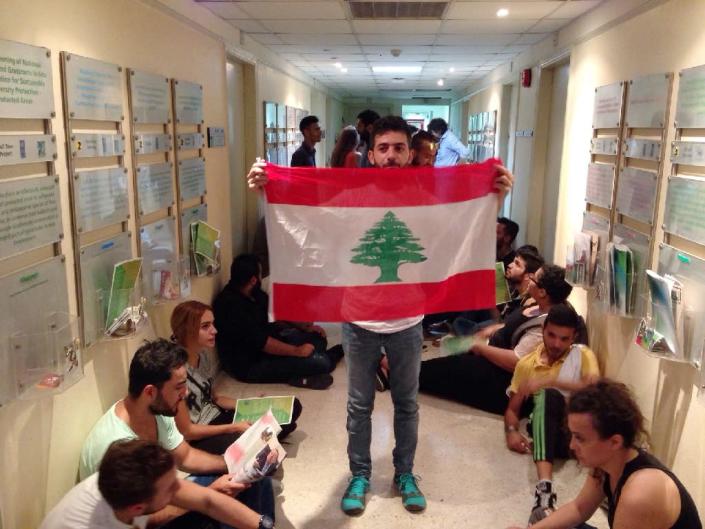 A Lebanese activist holds a national flag in a hallway during a surprise sit-in at Lebanon's environment ministry to demand the minister's resignation after mass protests over nationwide trash collection crisis on September 1, 2015 in Beirut (AFP Photo/)