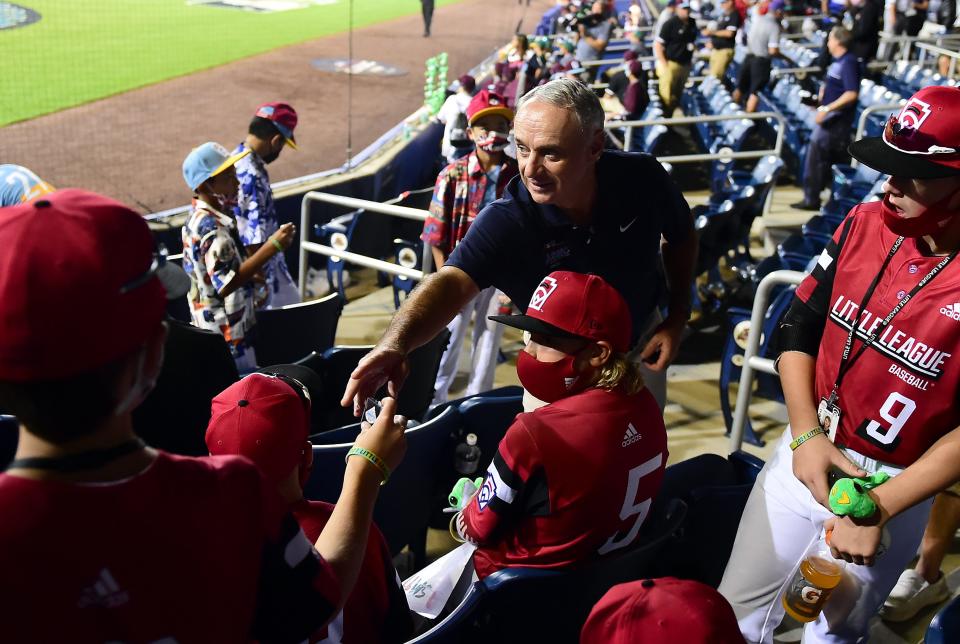 MLB commissioner Rob Manfred, seen here handing out pins to Little League players, has to consider that a prolonged labor dispute risks alienating members of Generation Z.