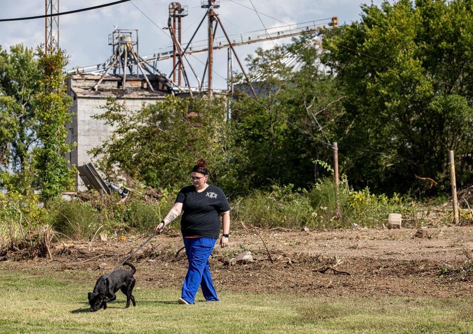 Megan Crawford walks a dog during her shift at the Mayfield-Graves County Animal Shelter in Mayfield, Ky. Crawford previously worked at the Mayfield Consumer Products candle factory, where she survived its destruction by a massive EF4 tornado on Dec. 10, 2021.