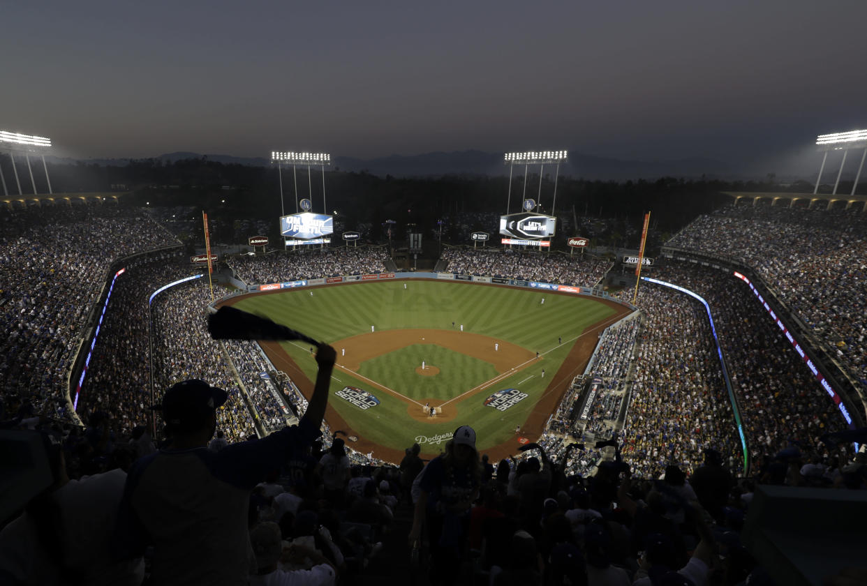 Fans cheer from the top of Dodger Stadium during Game 4 of the World Series baseball game between the Boston Red Sox and Los Angeles Dodgers on Saturday, Oct. 27, 2018, in Los Angeles. (AP Photo/Elise Amendola)