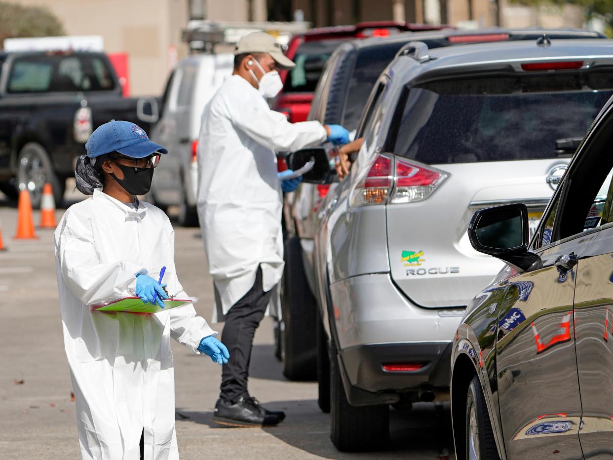 In this 19 November 2020, file photo, healthcare workers process people waiting in line at a United Memorial Medical Centre Covid-19 testing site in Houston. ((Associated Press))