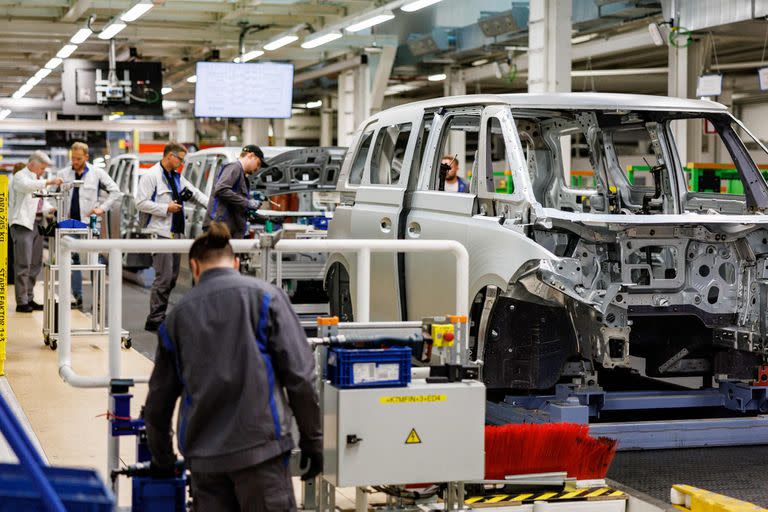 Mechanics work at the assembly line of a VW ID Buzz, the new fully electric-driven microbus of Volkswagen Commercial Vehicles, at the Volkswagen plant in Hanover, northern Germany on June 16, 2022. - The company plans to build 130,000 units of the car per year in Hanover. (Photo by Axel Heimken / AFP)