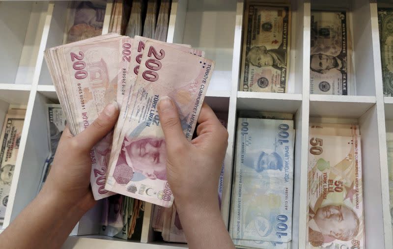 FILE PHOTO: A money changer counts Turkish lira bills at an currency exchange office in central Istanbul, Turkey