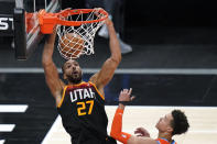 Utah Jazz center Rudy Gobert (27) dunks as Oklahoma City Thunder center Isaiah Roby watches during the second half of an NBA basketball game Tuesday, April 13, 2021, in Salt Lake City. (AP Photo/Rick Bowmer)