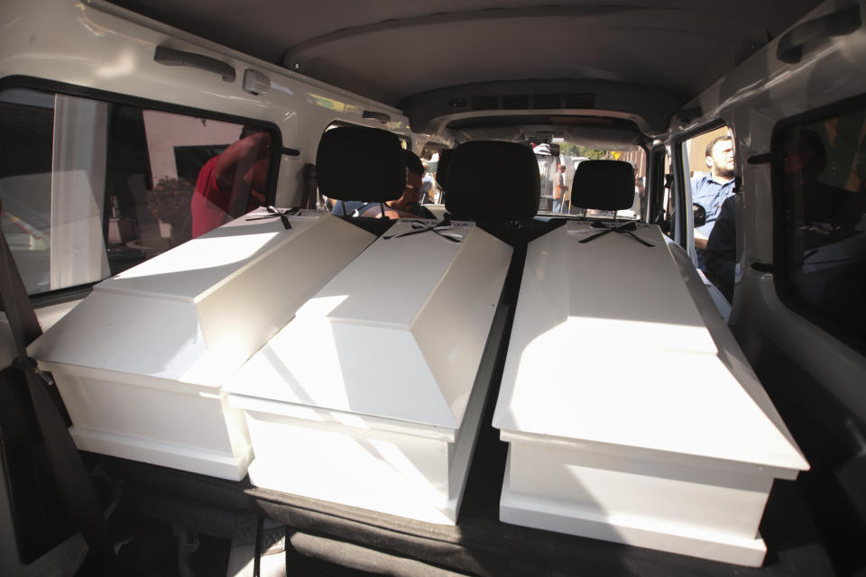 Coffins holding the remains of three of six family members who were killed in a 1982 massacre are transported by the forensic office to be handed over to the victims' family in San Salvador, El Salvador, Thursday, Jan. 23, 2020. The remains of six adults and children from one family were handed over to surviving relatives on Thursday, 38 years after the El Calabozo massacre in which government soldiers are accused of killing more than 200 people. (AP Photo/Salvador Melendez)