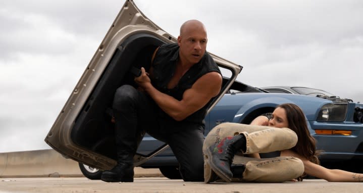 Vin Diesel holds a car door like a shield in a still from Fast X