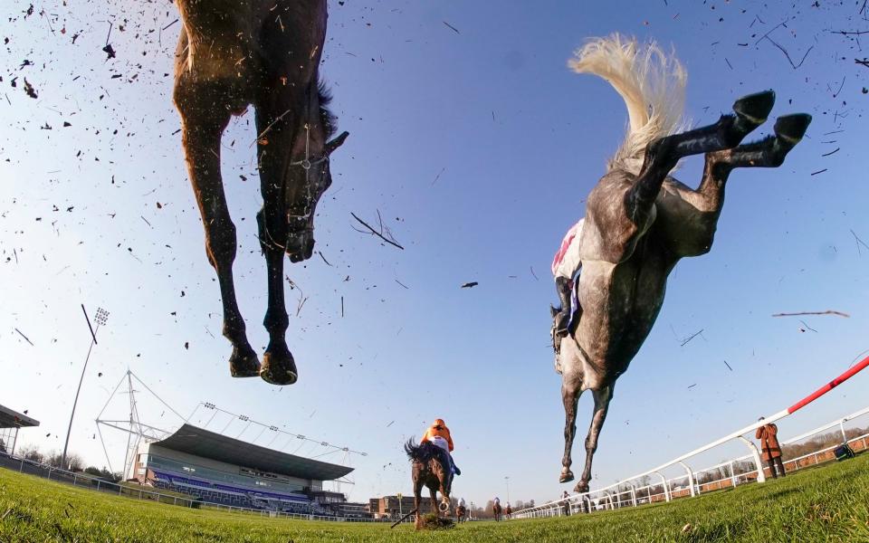 Action as runners clear a fence in the straight during The Close Brothers Handicap Chase at Kempton Park  - PA