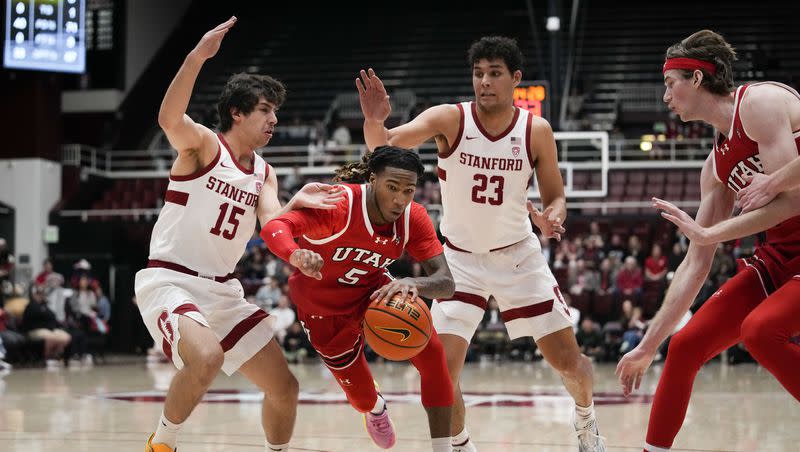 Utah guard Deivon Smith (5) dribbles between Stanford guard Benny Gealer (15) and forward Brandon Angel (23) during the first half of an NCAA college basketball game, Sunday, Jan. 14, 2024, in Stanford, Calif. 