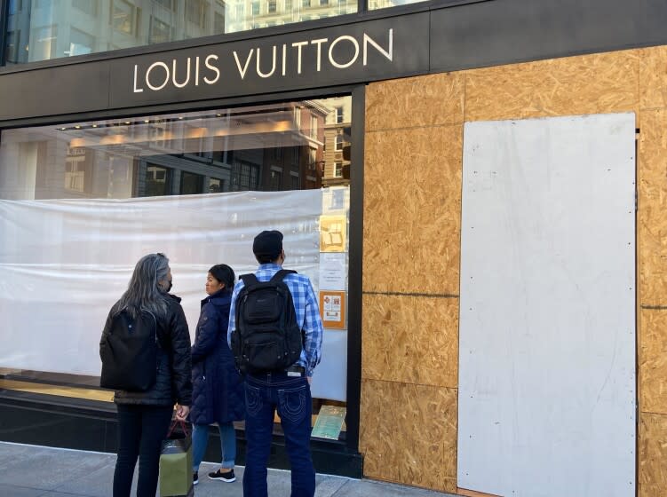 Union Square visitors look at damage to the Louis Vuitton store on Sunday, Nov. 21, 2021, after looters ransacked businesses late Saturday night in San Francisco. (Danielle Echeverria/San Francisco Chronicle via AP)