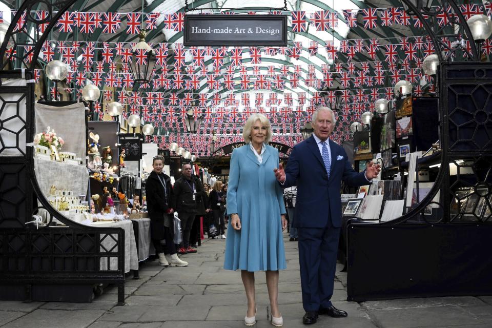 FILE - Britain's King Charles III, right, gestures as he stands next to Britain's Queen Camilla, left, during a visit at Covent Garden market, in central London, Wednesday May 17, 2023. At an age when many of his contemporaries have long since retired, King Charles III is not one to put his feet up. The king will mark his 75th birthday on Tuesday, Nov. 14, 2023, by highlighting causes close to his heart. With Queen Camilla at his side, Charles will visit a project that helps feed those in need by redistributing food that might otherwise go to landfills. (Daniel Leal/Pool via AP, File)