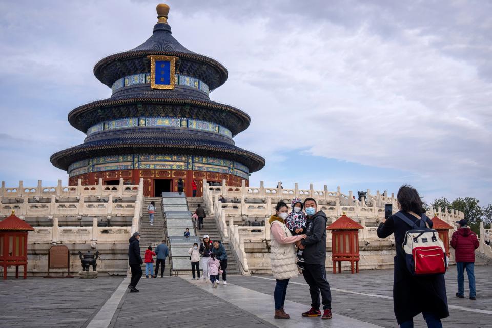 A family poses for photos at the Temple of Heaven in Beijing on Nov. 12, 2022. China has announced its first overall population decline in recent years amid an aging society and plunging birthrate.