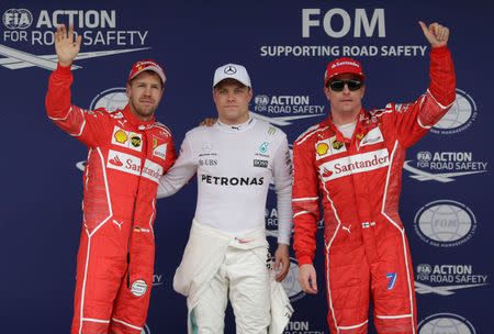 Formula One F1 - Brazilian Grand Prix 2017 - Sao Paulo, Brazil - November 11, 2017 Mercedes' Valtteri Bottas celebrates getting pole position with Ferrari's Sebastian Vettel and Kimi Raikkonen after qualifying REUTERS/Ueslei Marcelino