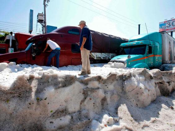 Men remain next to trucks buried in hail in the eastern area of Guadalajara, Jalisco state, Mexico (AFP/Getty Images)