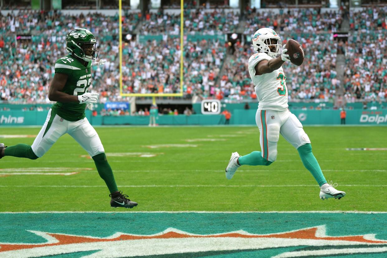 Miami Dolphins running back Raheem Mostert (31) scores a touchdown past New York Jets safety Tony Adams (22) during the first half of an NFL game at Hard Rock Stadium in Miami Gardens, Dec. 17, 2023.