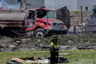 <p>Police officers stand guard at the site after a series of explosions at fireworks warehouses in Tultepec, central Mexico, on July 5, 2018. – At least 17 people were killed, including rescue workers who died saving others’ lives, officials said. The initial explosion occurred around 9:30 am (1430 GMT), then spread to other warehouses just as police and firefighters began attending to the first victims. (Photo: Pedro Pardo/AFP/Getty Images) </p>