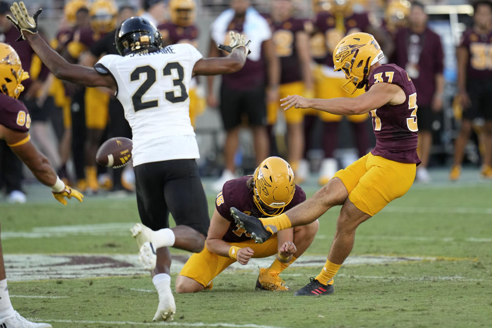 Arizona State place-kicker Dario Longhetto (37) boots a field goal with the help of holder Josh Carlson (16) as Colorado cornerback Carter Stoutmire (23) applies late pressure during the first half of an NCAA college football game Saturday, Oct. 7, 2023, in Tempe, Ariz. (AP Photo/Ross D. Franklin)