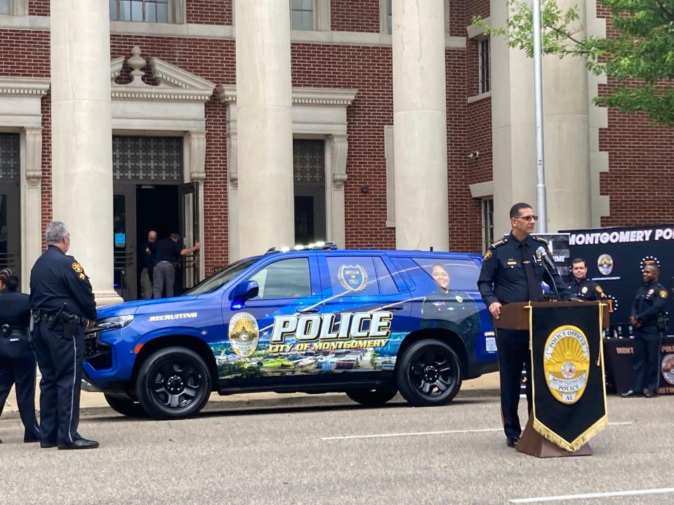 Police Chief Darryl Albert unveils the city's newest recruitment tool, a blue SUV with recruitment information plastered on its sides.