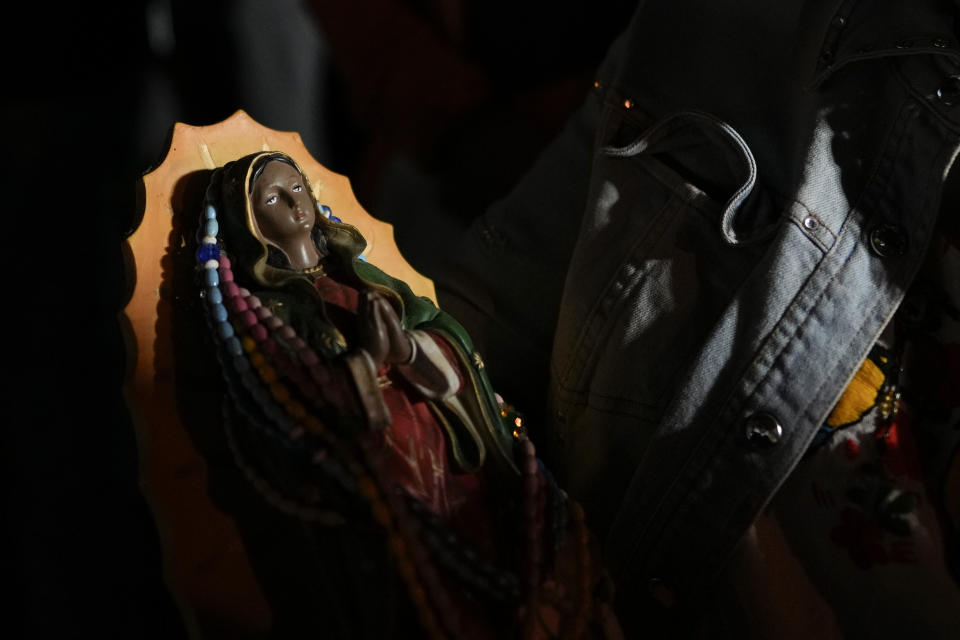 Francisca Santiago, a farm worker originally from Oaxaca, Mexico, carries a figure of the Virgin of Guadalupe, as he attends a festival celebrating one of several apparitions of the Virgin Mary witnessed by an indigenous Mexican man named Juan Diego in 1531, at St. Ann Mission in Naranja, Fla., before dawn on Sunday, Dec. 10, 2023. For this mission church where Miami's urban sprawl fades into farmland and the Everglades swampy wilderness, it's the most important event of the year, both culturally and to fundraise to continue to minister to the migrant farmworkers it was founded to serve in 1961. (AP Photo/Rebecca Blackwell)