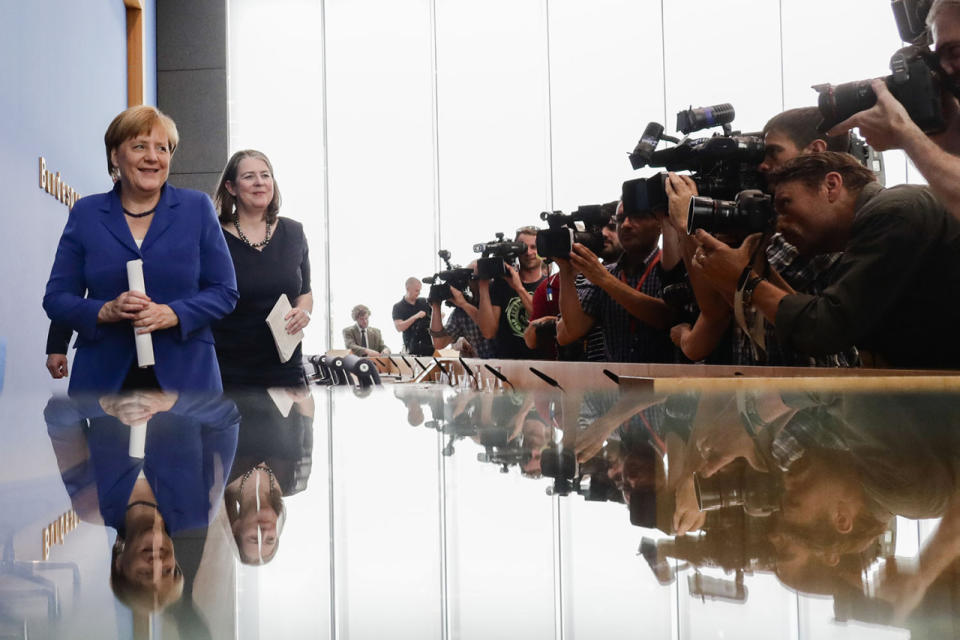 <p>Photographers and television cameras cover German Chancellor Angela Merkel as she leaves a news conference in Berlin, Germany, July 28, 2016. Second left is Angela Wefers, the journalist who led the news conference. (Photo: Markus Schreiber/AP)</p>