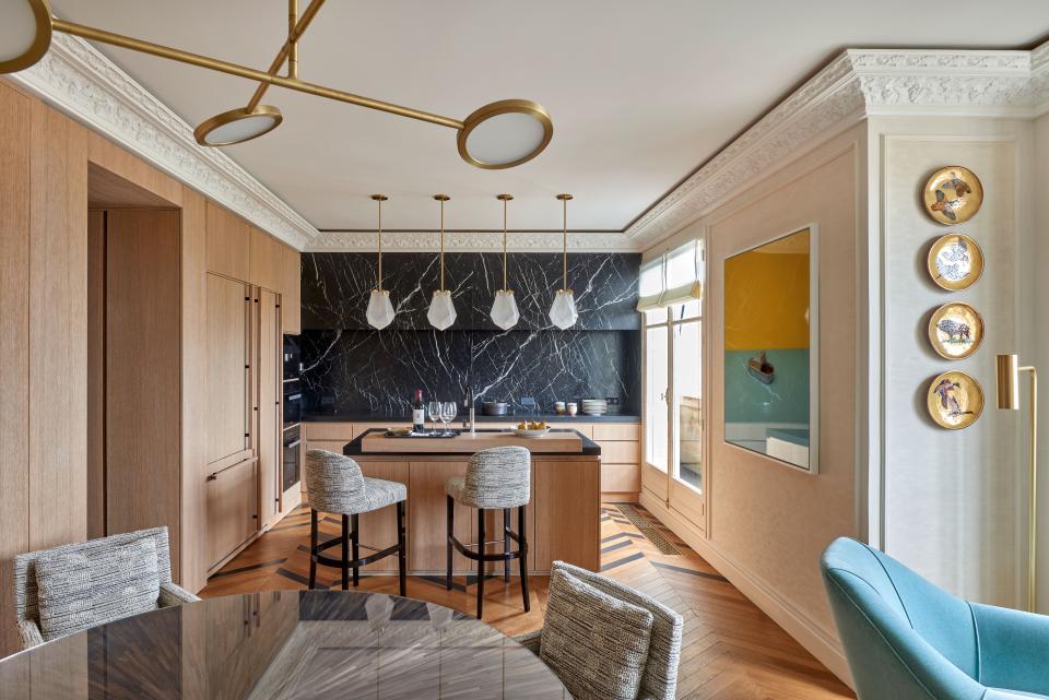 With views on the Invalides esplanade, the custom kitchen was designed by Sandrine Teze-Limal. The clients wanted a gourmet kitchen in the middle of the traditional architecture. Wood added the four jewel-like pendant lights called Briolette by Gabriel Scott and the Discus 4 hanging by Jamie Gray. Both were sourced from Triode Paris. The Richard Caldicott photograph is titled Anchovies and was purchased at the Paris Photo Fair. The plates on the wall were found at the Paris Flea Market.