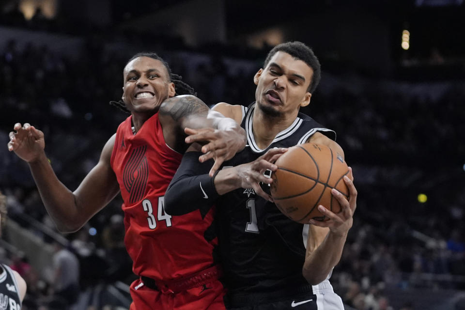 San Antonio Spurs center Victor Wembanyama (1) grabs a rebound next to Portland Trail Blazers forward Jabari Walker (34) during the first half of an NBA basketball game in San Antonio, Friday, Jan. 26, 2024. (AP Photo/Eric Gay)