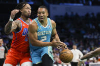 Charlotte Hornets forward Grant Williams, right, loses control of the ball as he drives into Oklahoma City Thunder forward Jaylin Williams during the first half of an NBA basketball game in Charlotte, N.C., Sunday, April 7, 2024. (AP Photo/Nell Redmond)