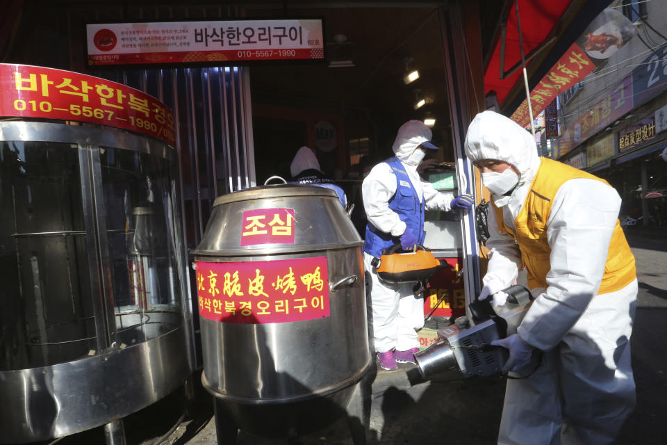 Workers wearing protective gear spray disinfectant at a Chinese duck restaurant as a precaution against a new coronavirus at Daelim market in Seoul, South Korea, Wednesday, Feb. 5, 2020. Deaths from a new virus rose to 490 in mainland China on Wednesday while new cases on a Japanese cruise ship, in Hong Kong and in other places showed the increasing spread of the outbreak and renewed attention toward containing it. (AP Photo/Ahn Young-joon)