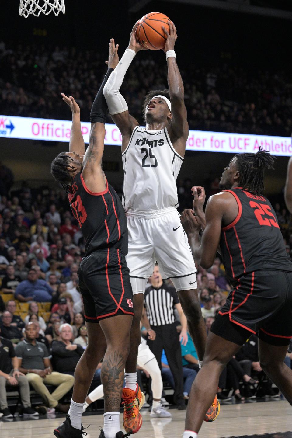 Central Florida forward Taylor Hendricks goes up for a shot between Houston forward J'Wan Roberts (13) and forward Jarace Walker (25) on Jan. 25, 2023, in Orlando.