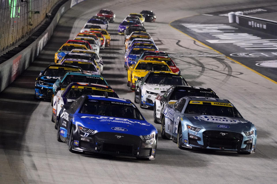 Chris Buescher, front left, and Kevin Harvick (4) lead the pack during a restart at a NASCAR Cup Series auto race at Bristol Motor Speedway Saturday, Sept. 17, 2022, in Bristol, Tenn. (AP Photo/Mark Humphrey)