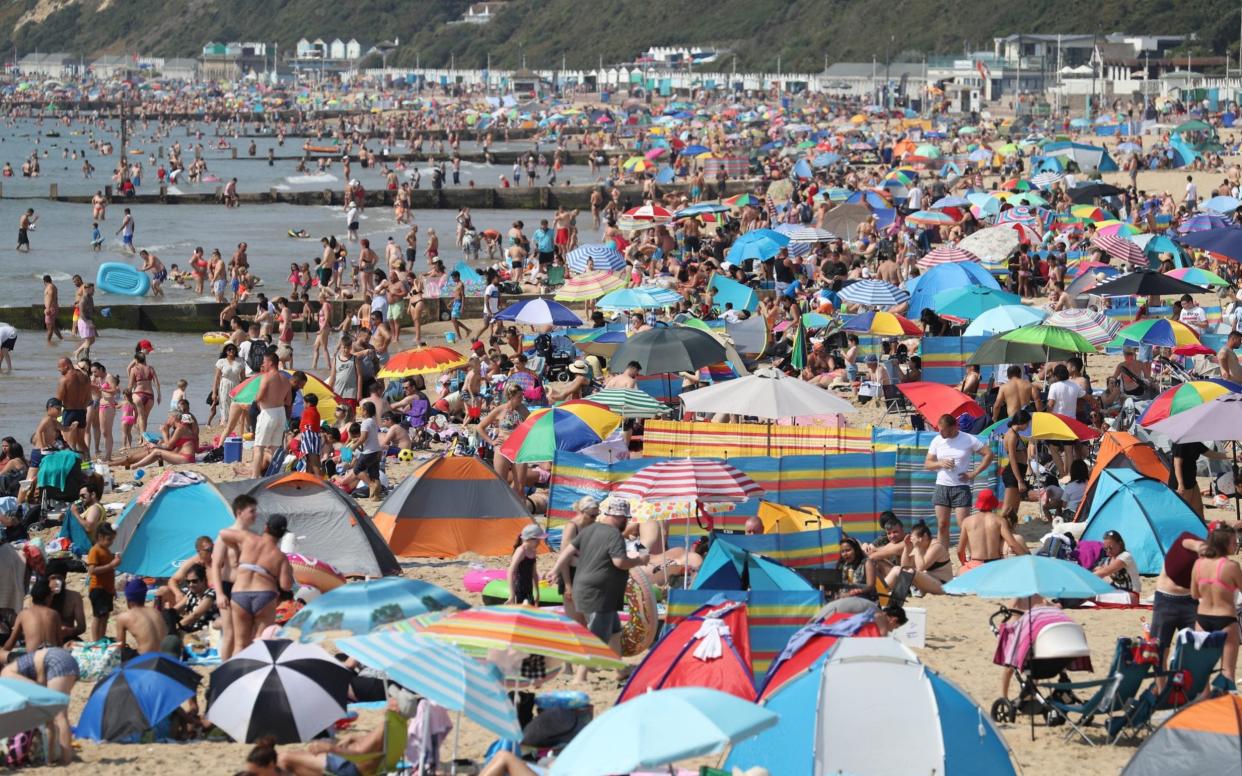 Sunbathers on Bournemouth beach in Dorset - PA