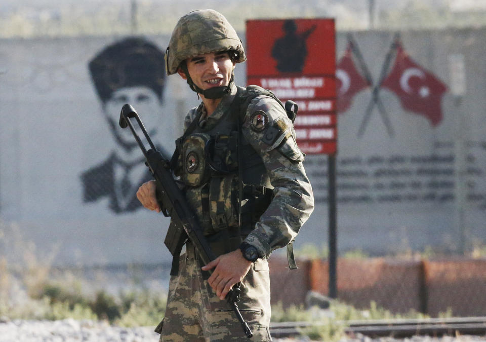 FILE-In this Wednesday, Oct. 9, 2019 file photo, shortly after the Turkish operation inside Syria had started, a Turkish soldiers stands at the border with Syria in Akcakale, Sanliurfa province, southeastern Turkey. Since Turkey announced its incursion into neighbouring Syria to clear out Kurdish fighters last week, patriotic sentiment has run high, with signs of the glory days of the Ottoman Empire among the outward signs of patriotism. (AP Photo/Lefteris Pitarakis, File)