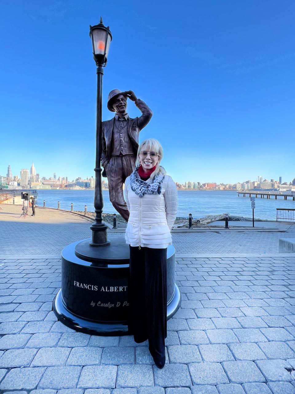 Carolyn Palmer stands next to the statue of Frank Sinatra she sculpted. The statue is in Hoboken, Sinatra's hometown.