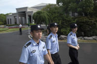 Chinese police officers patrol outside the Xijiao Conference Center where U.S. and Chinese trade officials have gathered for talks in Shanghai on Wednesday, July 31, 2019. (AP Photo/Ng Han Guan, Pool)