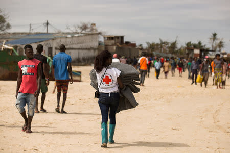 Volunteer from the Mozambique Red Cross carries supplies for survivors of Cyclone Idai, at an evacuation centre in Beira, Mozambique, March 21, 2019. Denis Onyodi/Red Cross Red Crescent Climate Centre/Handout via REUTERS